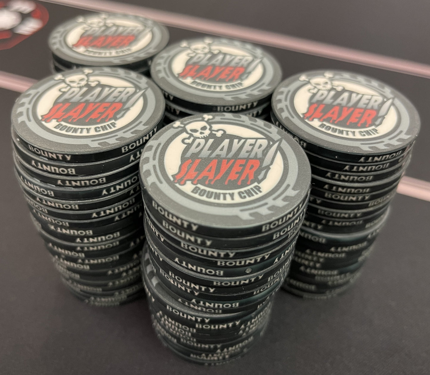 Shown here are the black Player Slayer Bounty chips, an Aurora Poker Gear exclusive design. These are 39mm chips (actually closer to 40mm). They are made of a nearly unbreakable ceramic. In our quest to produce the highest quality poker chips in the world, we came across this proprietary ceramic-polymer blend and it blew every other type of ceramic chip out of the water. We have yet to see one chip or break.
