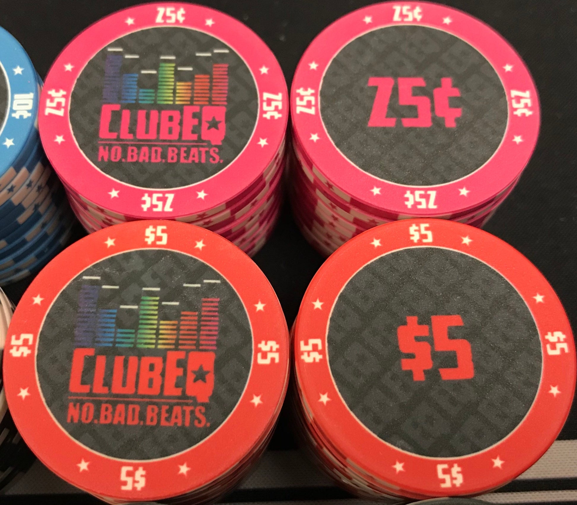 Here we see the twenty-five cent (25¢) and five dollar ($5) ClubEQ poker chips in magenta (pink) and red, respectively. The ClubEQ logo resembles a lighted EQ band. On the other side of each chip is the denomination in the same color as the poker chip.