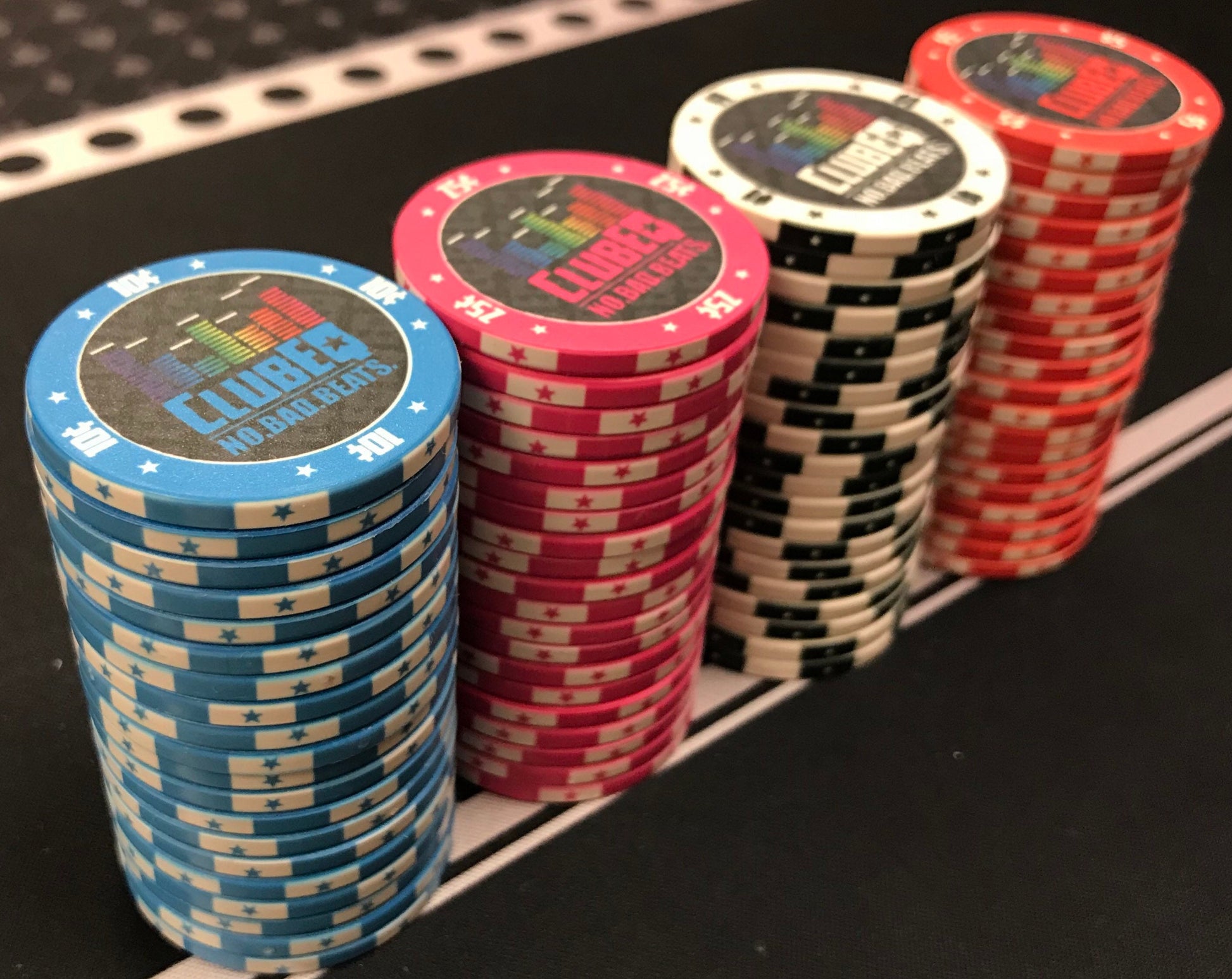 Four stacks of 20 ClubEQ designer poker chips. The ClubEQ blue 10¢, pink 25¢, white $1, and red $5 chips. (Ten cent, twenty-five cent, one dollar, five dollar.) If you're looking for unique poker chips, these are the answer.